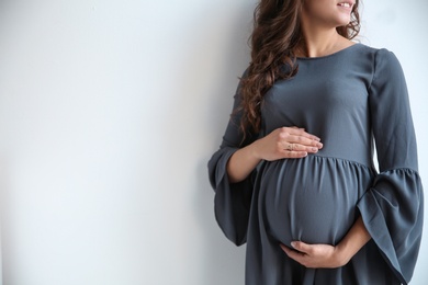 Happy young pregnant woman on white background. Space for text