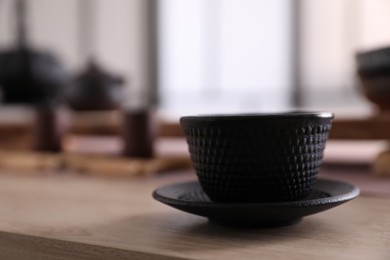 Photo of Cup with saucer for traditional tea ceremony on wooden table