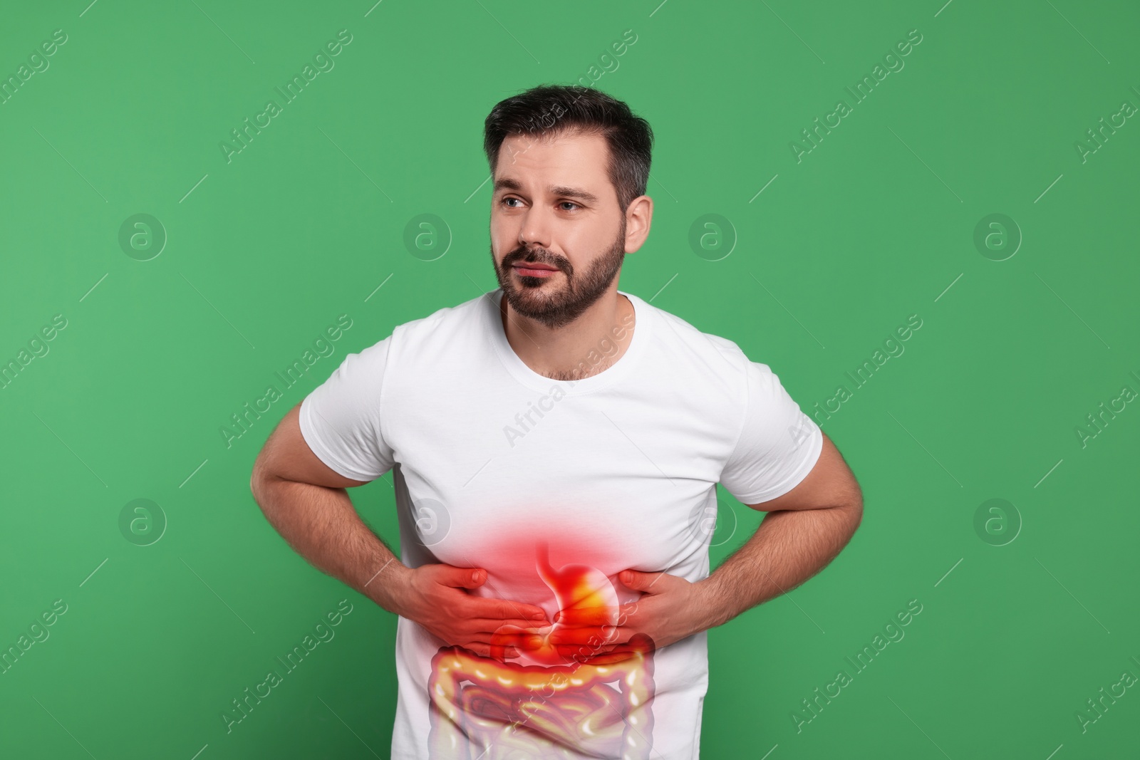 Image of Man suffering from stomach ache on green background. Illustration of unhealthy gastrointestinal tract