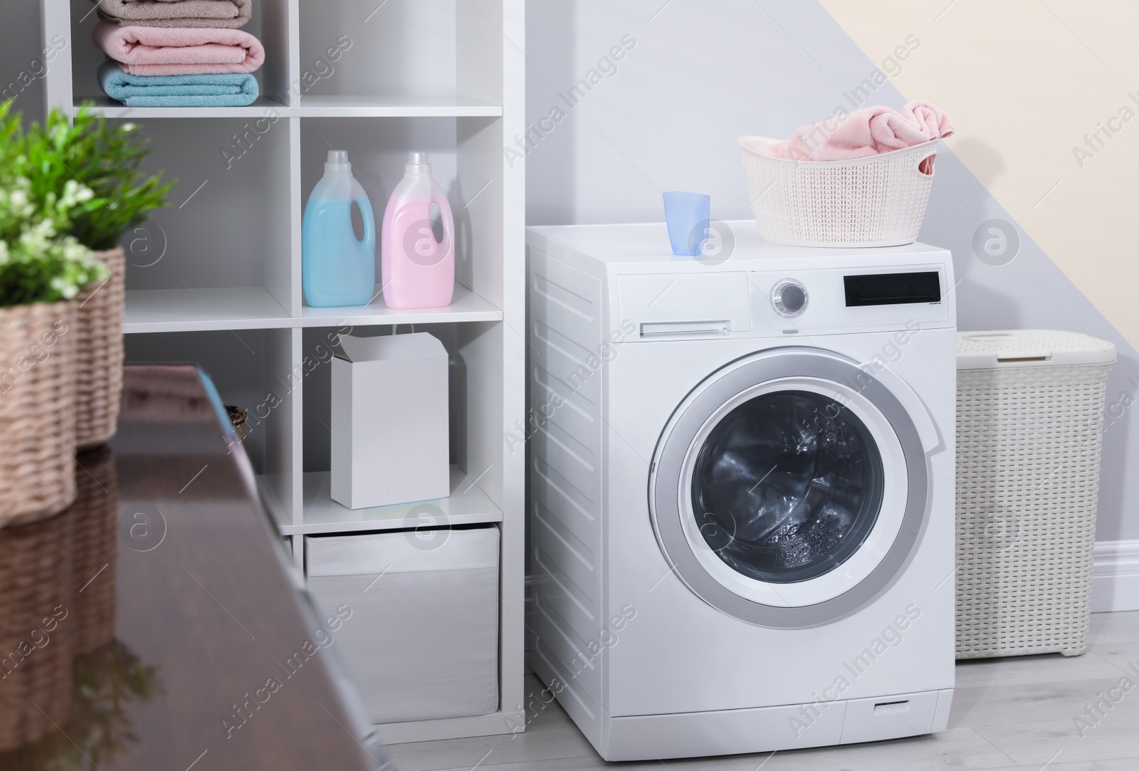 Photo of Modern washing machine in laundry room interior