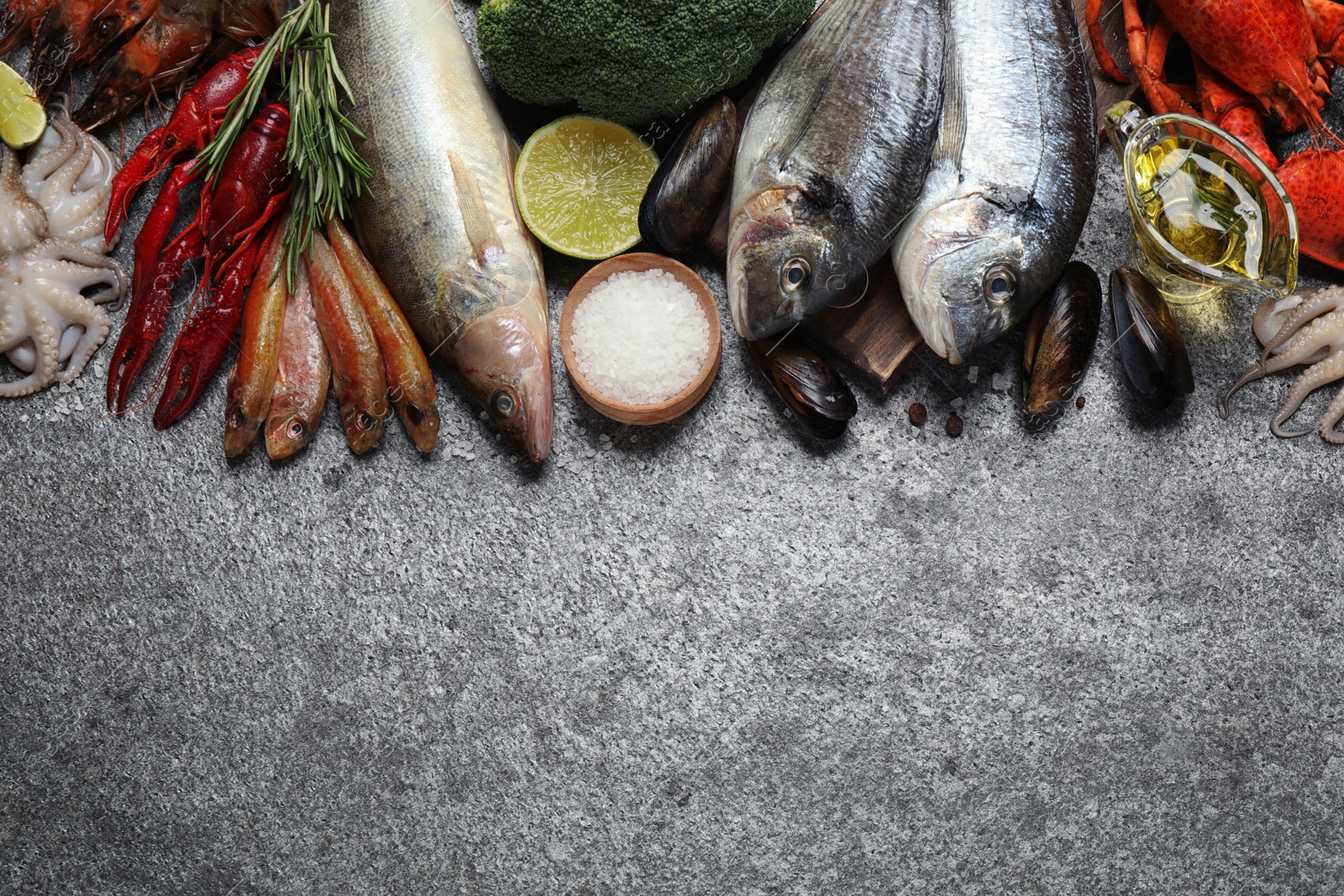 Photo of Fresh fish and different seafood on grey table, flat lay. Space for text