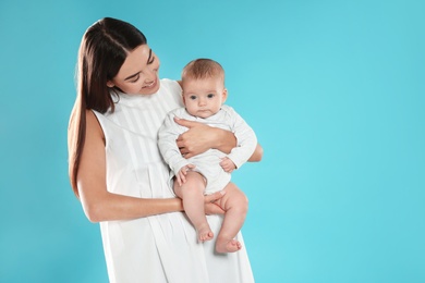 Photo of Portrait of happy mother with her baby on color background. Space for text