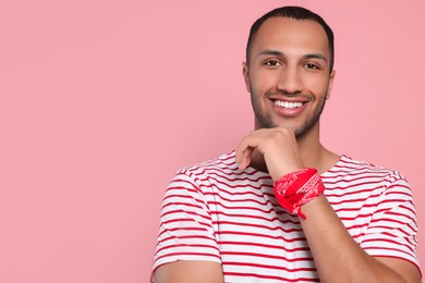 Photo of Portrait of happy African American man on pink background. Space for text
