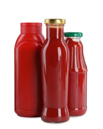 Different bottles of ketchup on white background