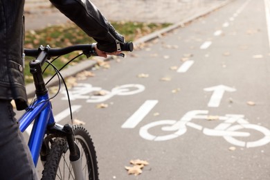Photo of Woman riding bicycle on lane in city, closeup