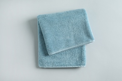 Photo of Fresh fluffy folded towel on grey background, top view. Mockup for design