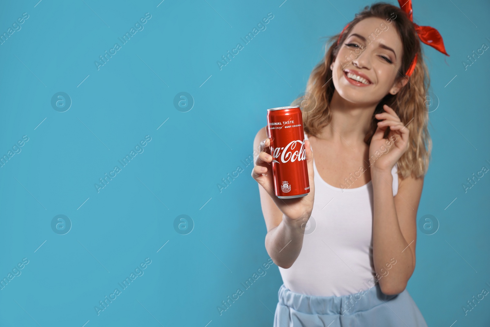 Photo of MYKOLAIV, UKRAINE - NOVEMBER 28, 2018: Young woman with Coca-Cola can on color background, space for text