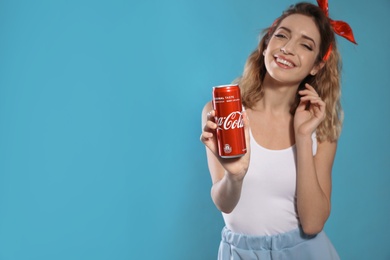 MYKOLAIV, UKRAINE - NOVEMBER 28, 2018: Young woman with Coca-Cola can on color background, space for text