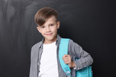 Photo of Back to school. Cute boy with backpack near chalkboard