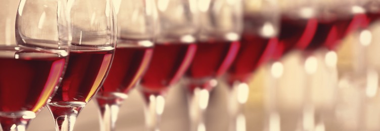 Image of Glasses with tasty red wine, closeup view. Banner design