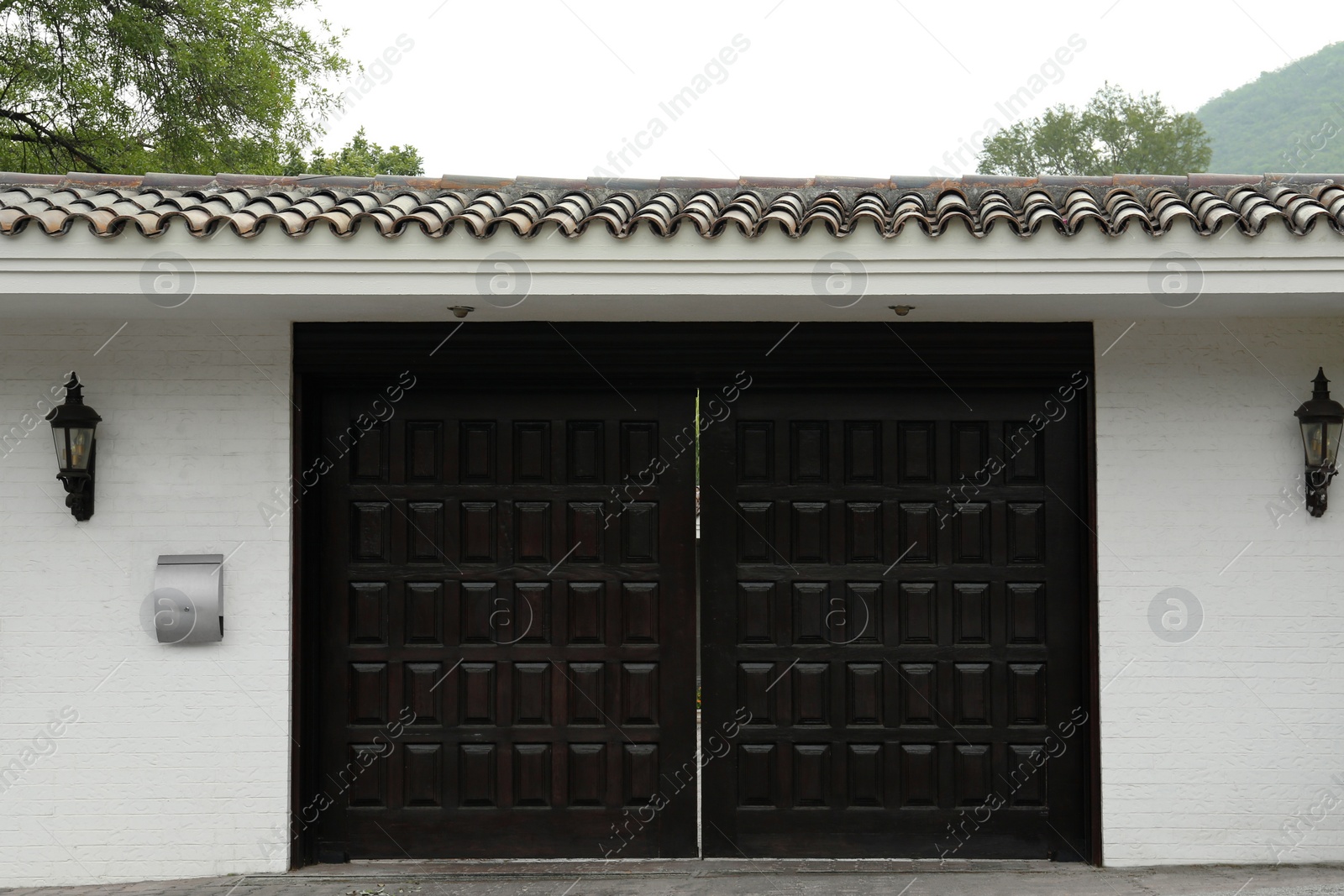 Photo of White wall with beautiful black gates. Exterior design