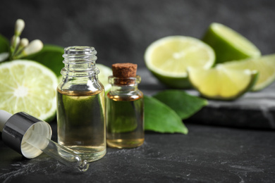 Photo of Bottles of citrus essential oil on black table. Space for text