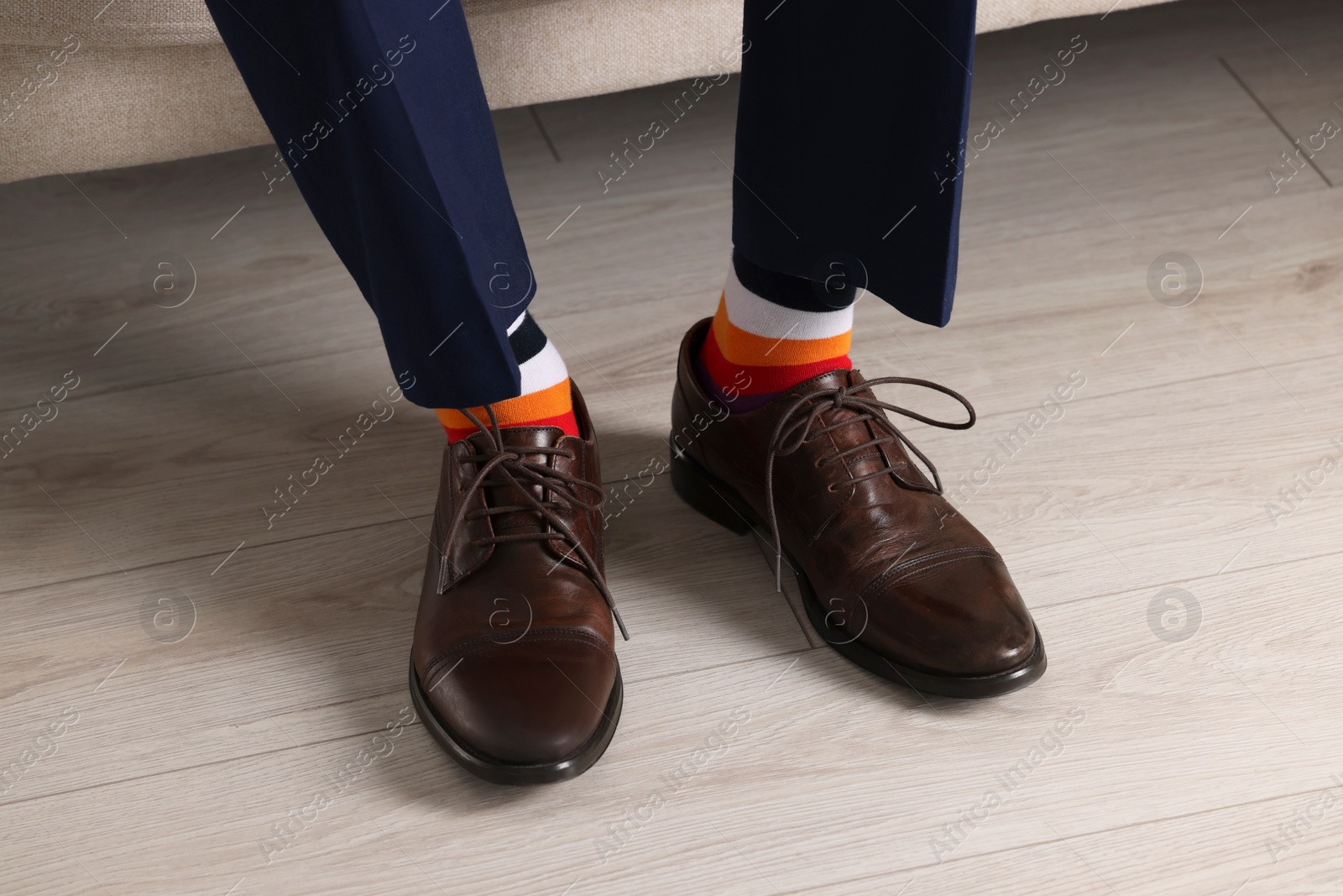 Photo of Man wearing stylish shoes and colorful socks indoors, closeup