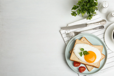 Photo of Tasty fried egg with bread and tomato on white wooden table, flat lay. Space for text