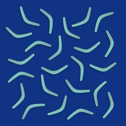Turquoise boomerangs on blue background, flat lay