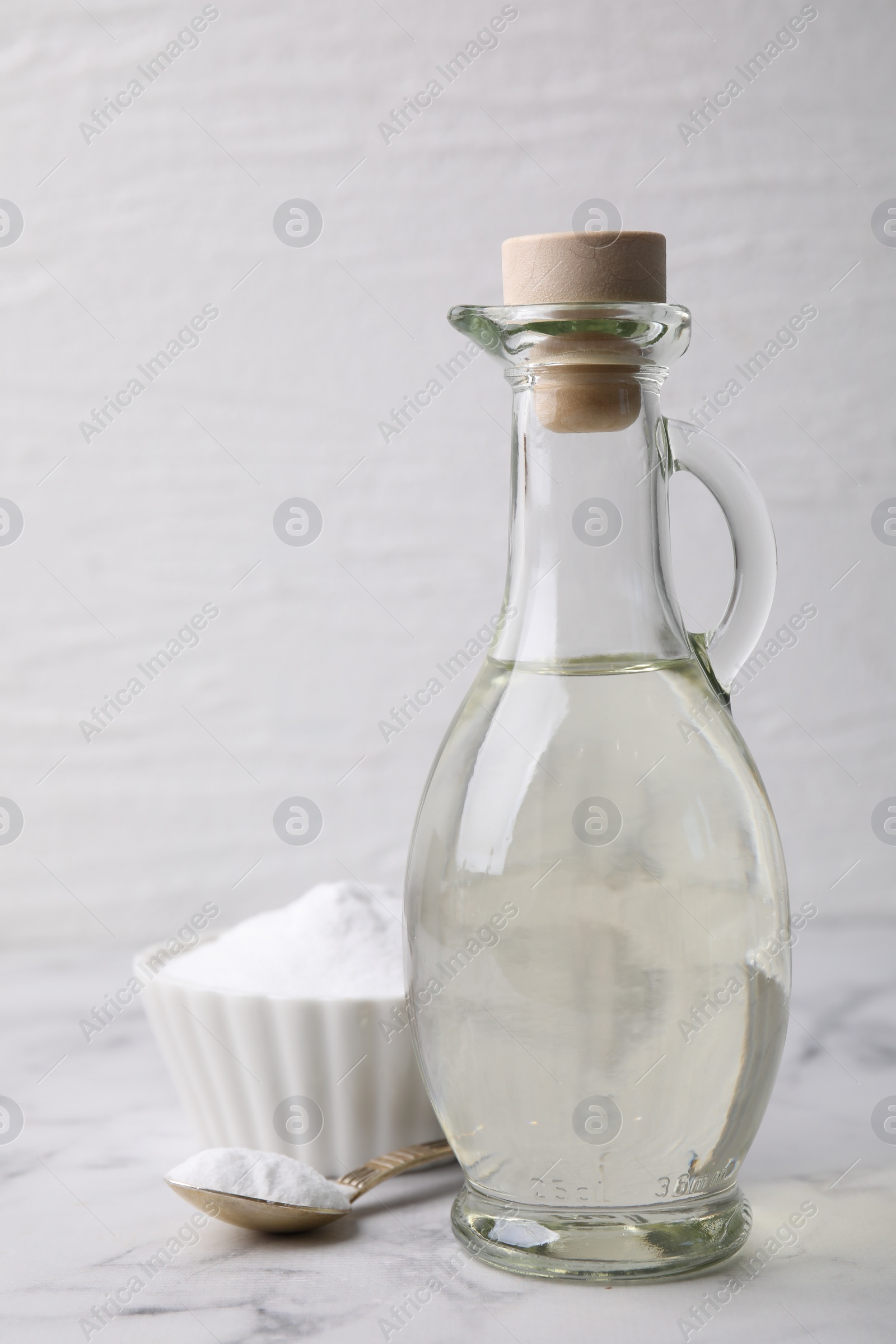 Photo of Vinegar and baking soda on white marble table