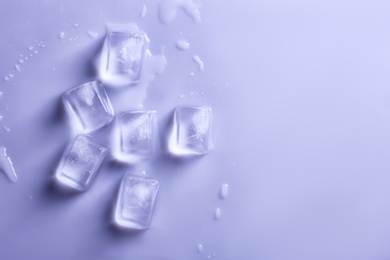 Photo of Ice cubes on color background, top view. Space for text