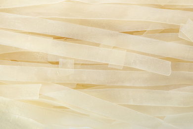 Photo of Raw rice noodles as background, closeup view