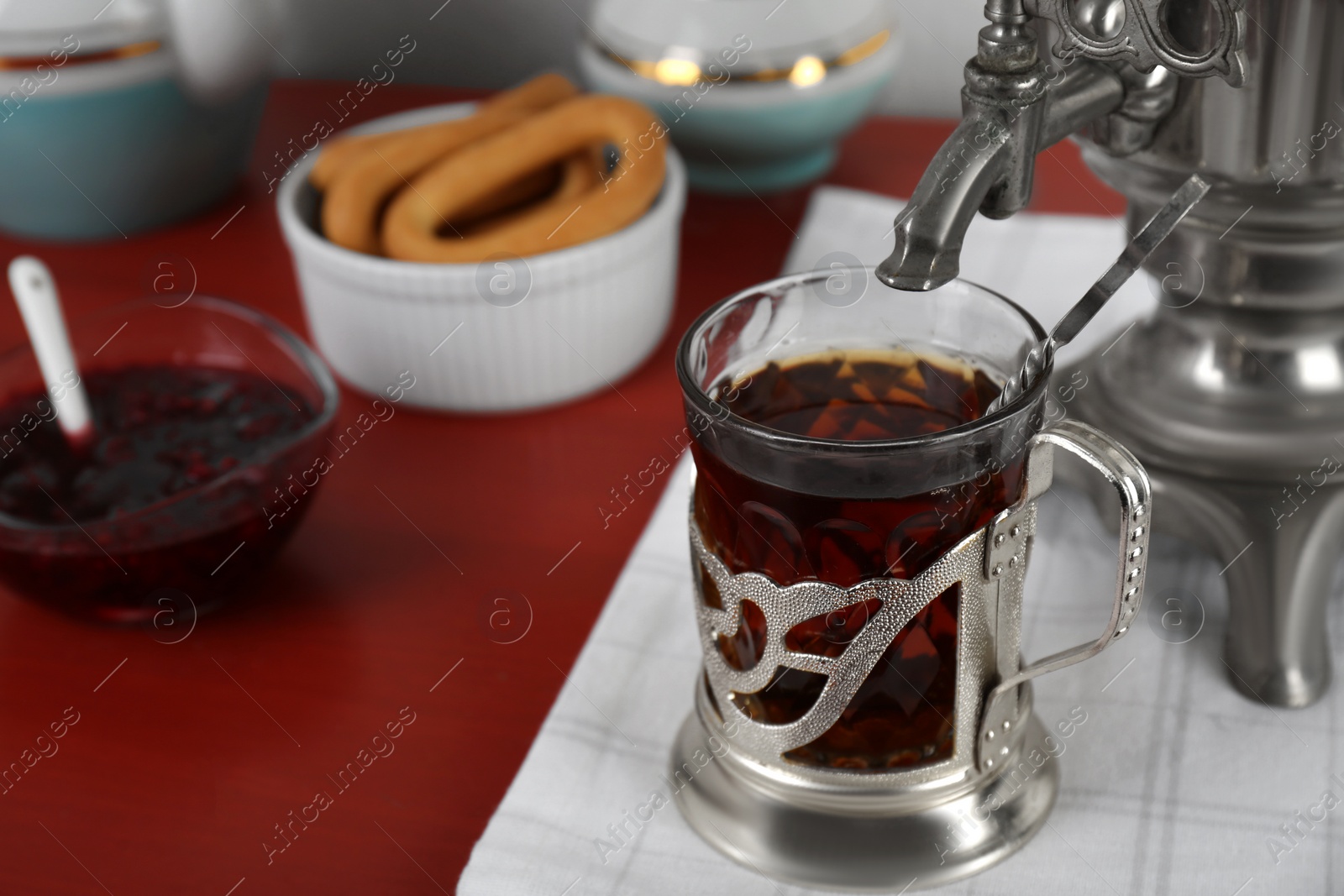 Photo of Delicious ring shaped Sushki (dry bagels), focus on cup of tea and samovar. Space for text