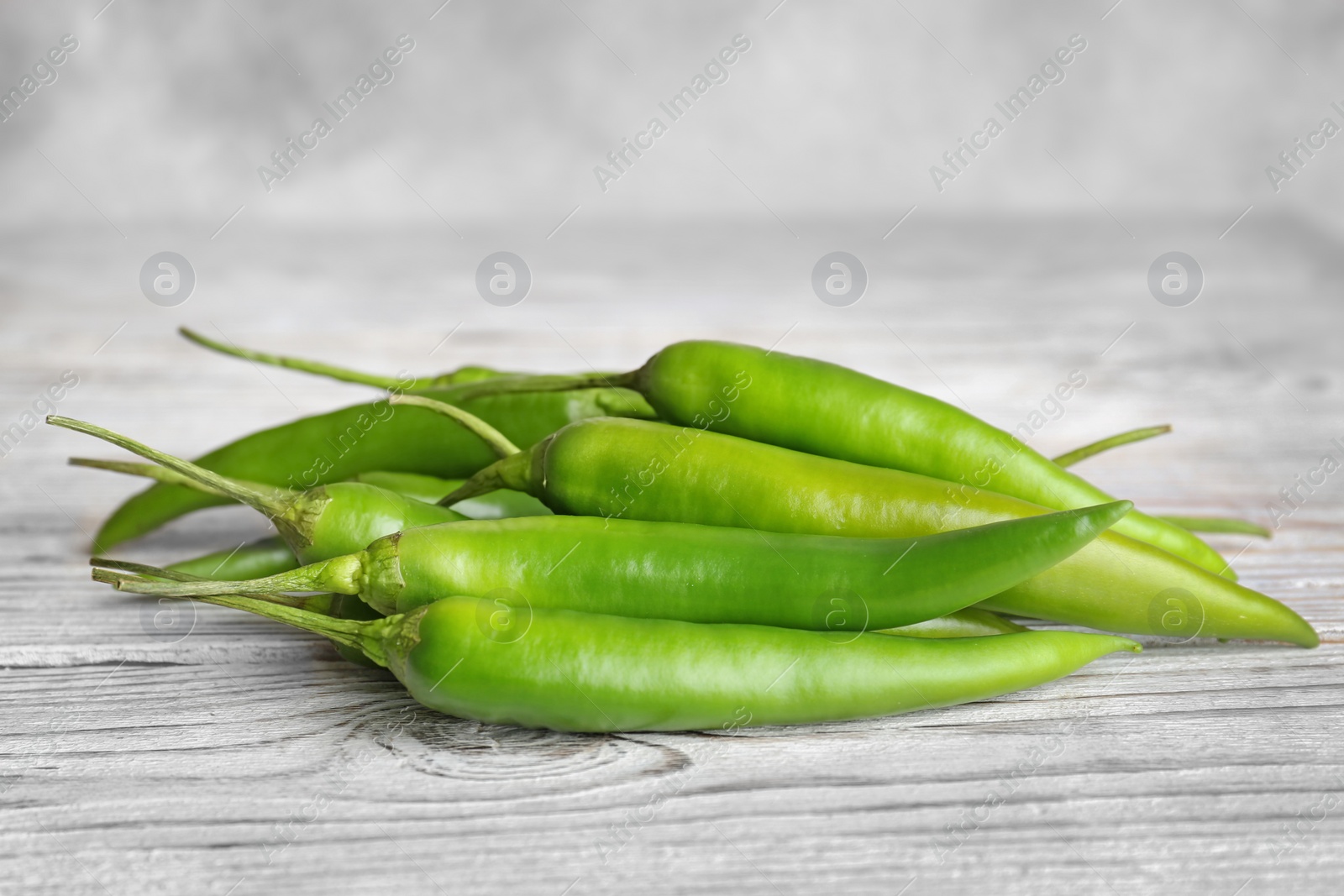 Photo of Pile of ripe chili peppers on wooden table