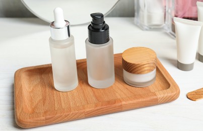 Photo of Different cosmetic products on white wooden table