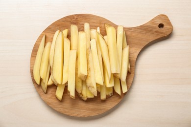 Photo of Cut raw potatoes on white wooden table, top view