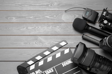 Photo of Flat lay composition with camera and video production equipment on grey wooden background. Space for text