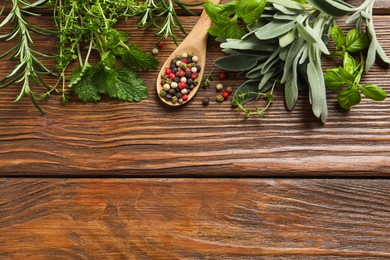 Photo of Different fresh herbs and spices on wooden table, flat lay. Space for text