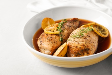 Photo of Baked lemon chicken with thyme served on white table