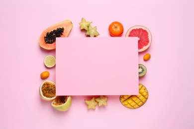 Photo of Different exotic fruits and blank card on pink background, flat lay. Space for text