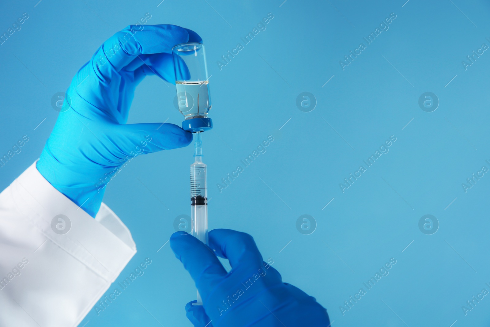 Photo of Doctor with syringe and medicine for vaccination on color background