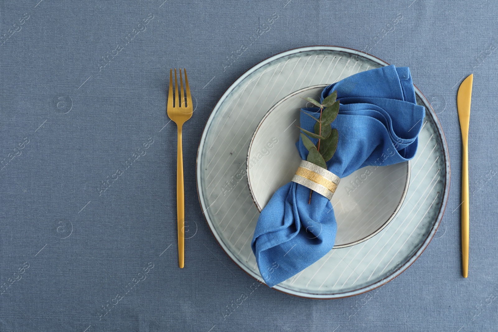 Photo of Stylish setting with cutlery, dishes, napkin and floral decor on table, top view. Space for text