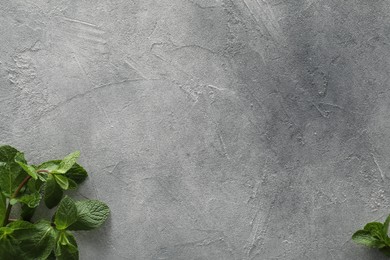 Photo of Food photography. Fresh aromatic mint leaves on grey textured table, flat lay with space for text