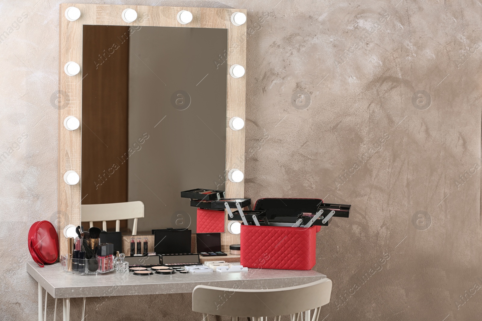 Photo of Dressing table with different makeup products and accessories in room interior. Space for text