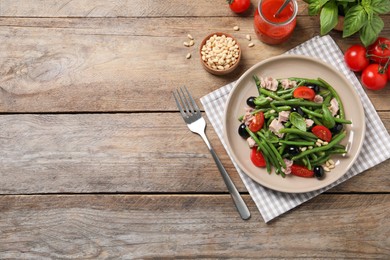 Photo of Tasty salad with green beans served on wooden table. Space for text