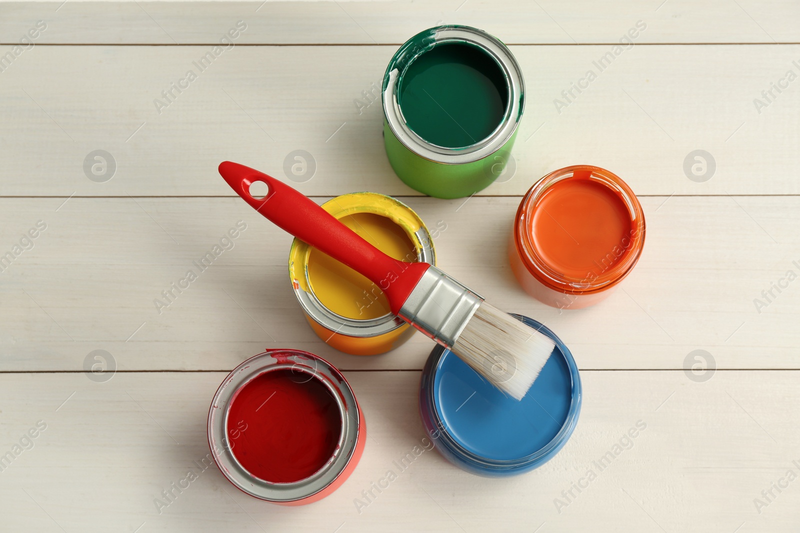 Photo of Different paints and brush on white wooden background, flat lay
