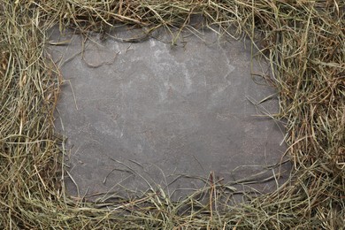 Photo of Frame made of dried hay on grey table, top view. Space for text