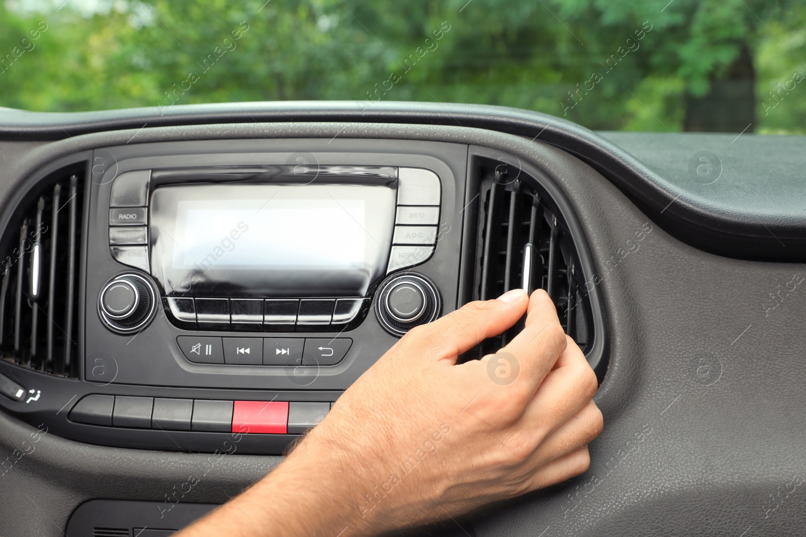 Photo of Man adjusting air conditioner in car, closeup