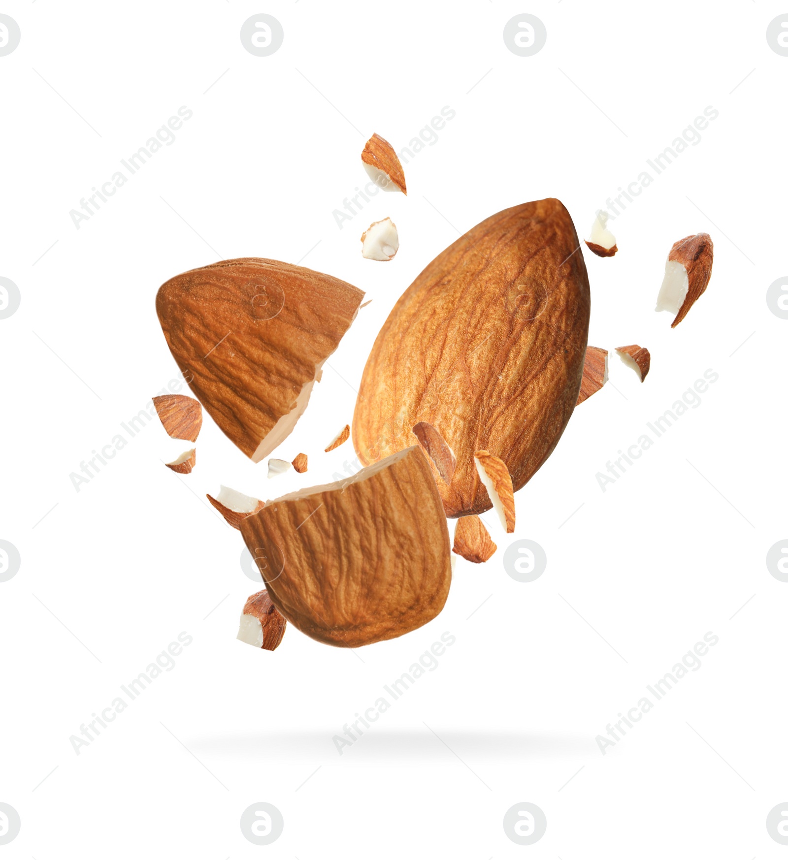 Image of Pieces of tasty almonds falling on white background