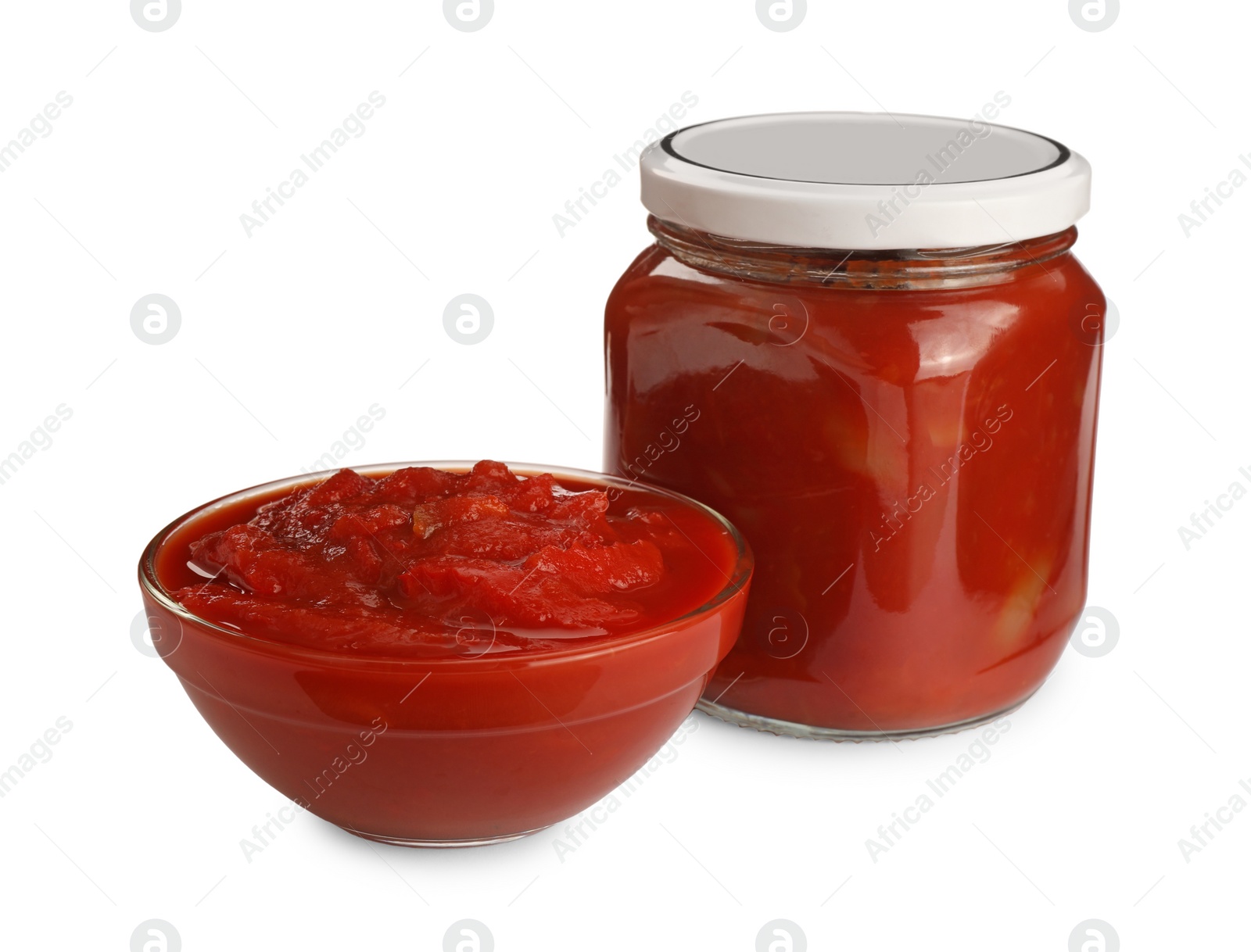 Photo of Glass jar and bowl of delicious lecho on white background