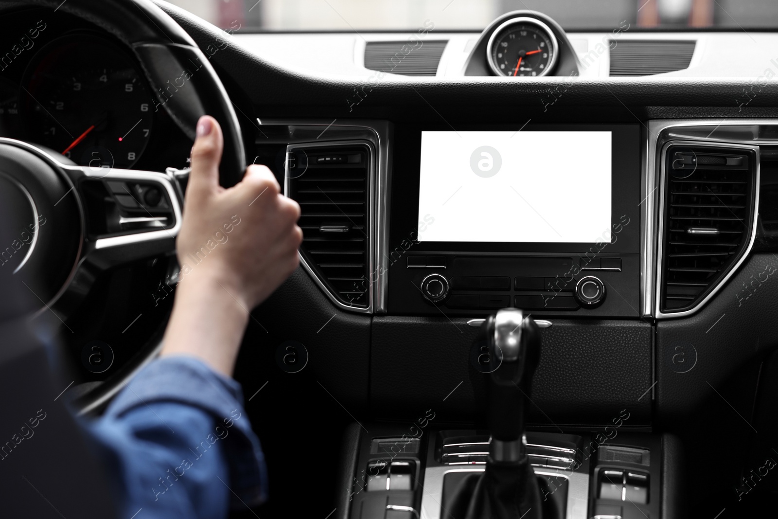 Photo of Woman using navigation system while driving her car, closeup