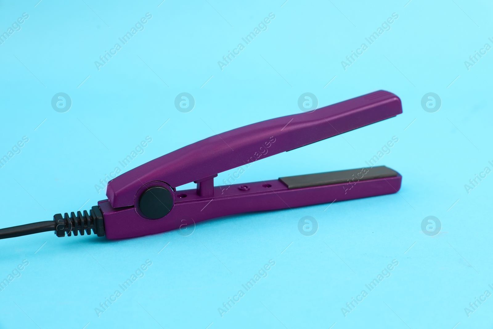 Photo of Modern hair iron for straightening on color background