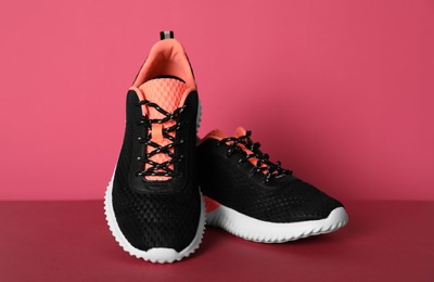 Pair of stylish sport shoes on pink background