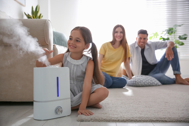 Family in room with modern air humidifier