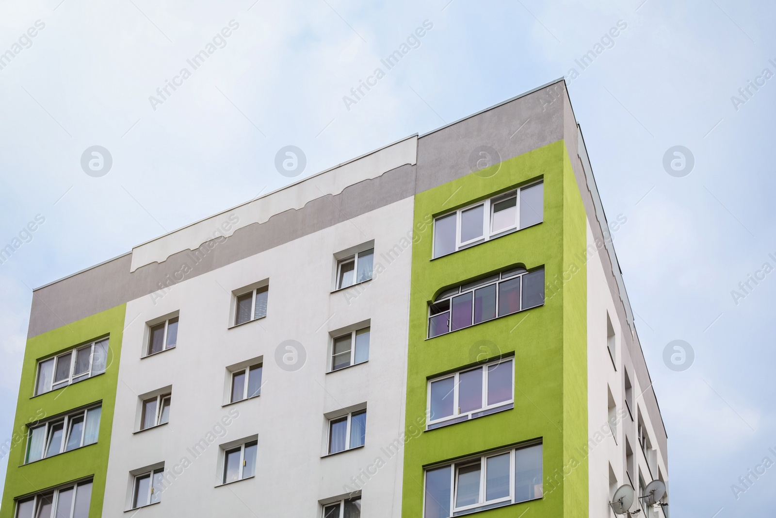 Photo of Multistorey apartment building against cloudy sky, low angle view