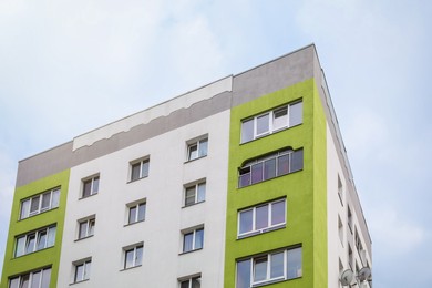 Multistorey apartment building against cloudy sky, low angle view