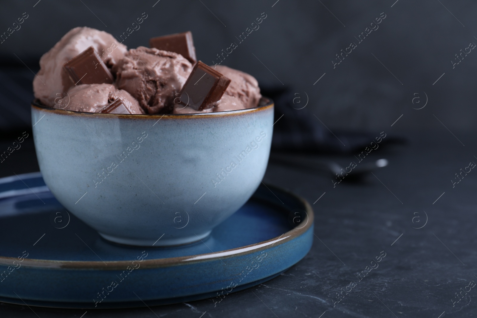 Photo of Yummy chocolate ice cream in bowl on black table. Space for text