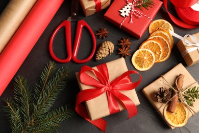 Photo of Flat lay composition with beautiful gift boxes and Christmas decorations on black table