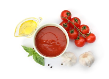Composition with bowl of tomato sauce and vegetables isolated on white, top view