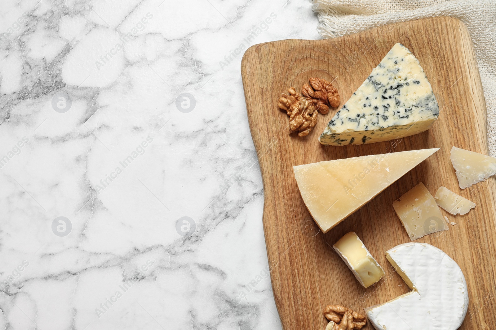 Photo of Different delicious cheeses served on marble table, top view. Space for text